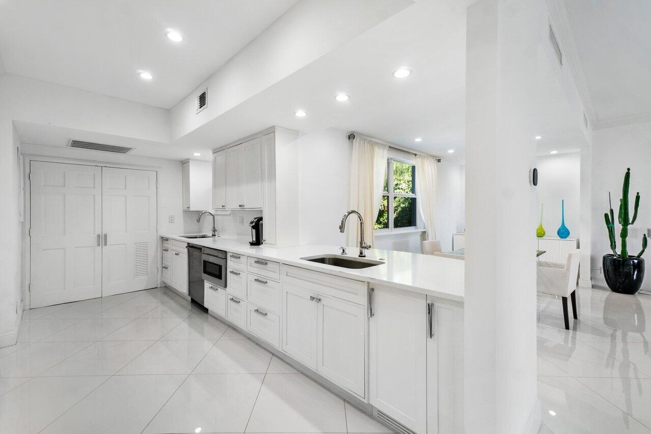 2665 North Ocean Boulevard, Unit 3 Gulf Stream, FL 33483 - Photo 27 of 50 a kitchen with white cabinets and sink
