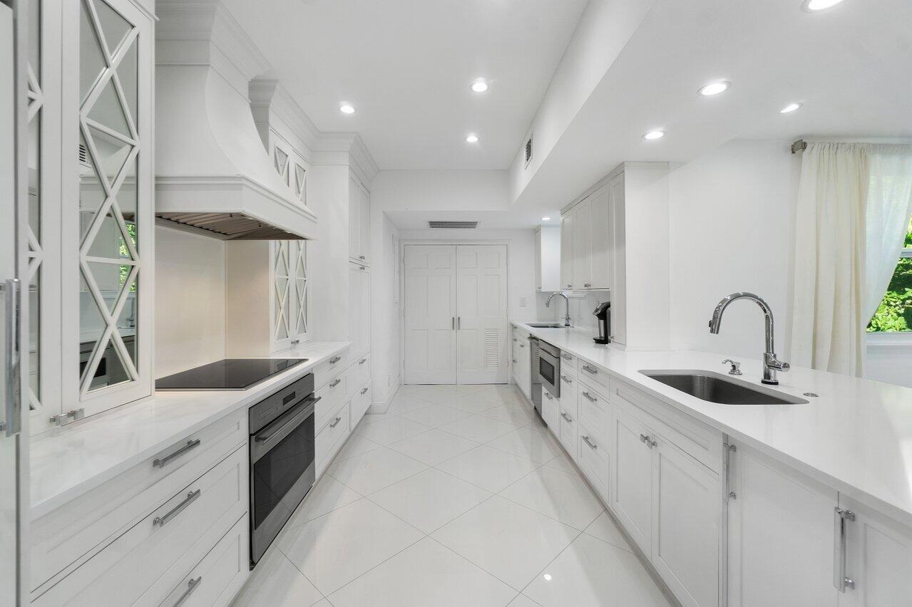 2665 North Ocean Boulevard, Unit 3 Gulf Stream, FL 33483 - Photo 10 of 50 a kitchen with granite countertop a sink and white cabinets