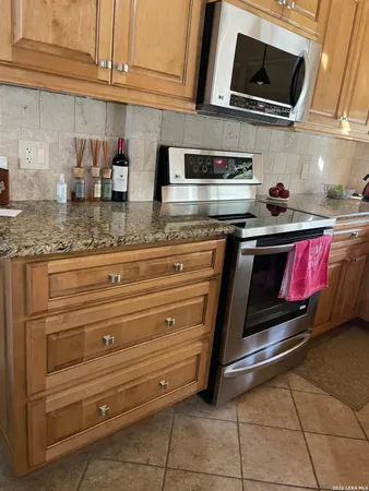 a kitchen with stainless steel appliances granite countertop a stove a microwave and cabinets