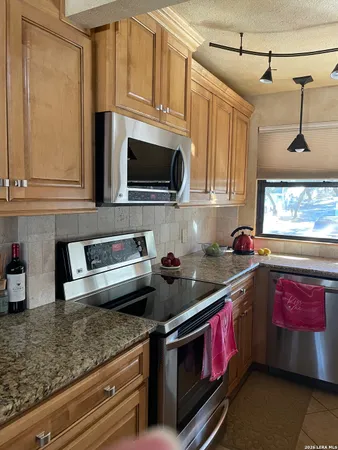 a bathroom with a granite countertop sink a mirror and a shower