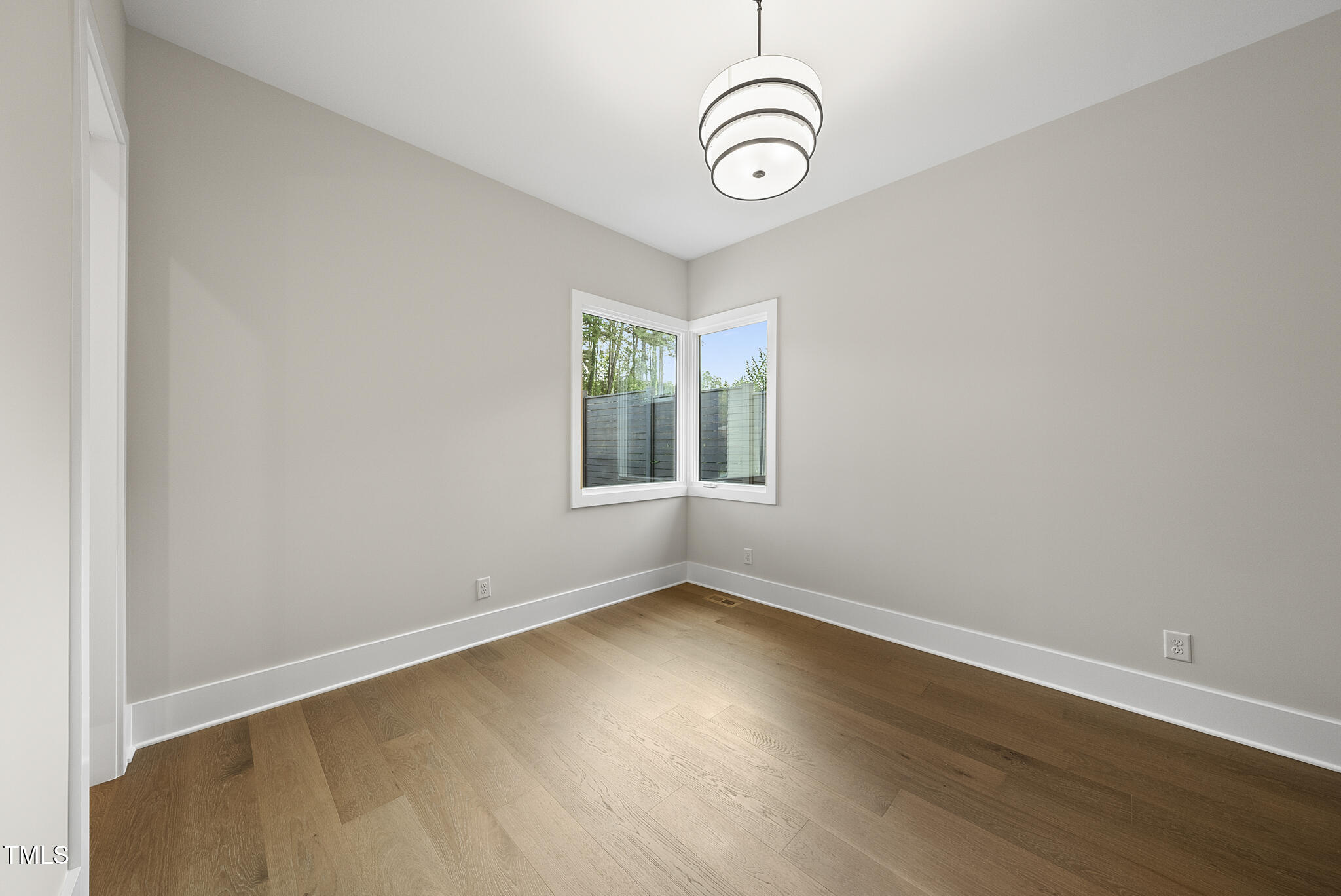 662 Manchester Drive Raleigh, NC 27609 - Photo 20 of 46 an empty room with wooden floor and windows