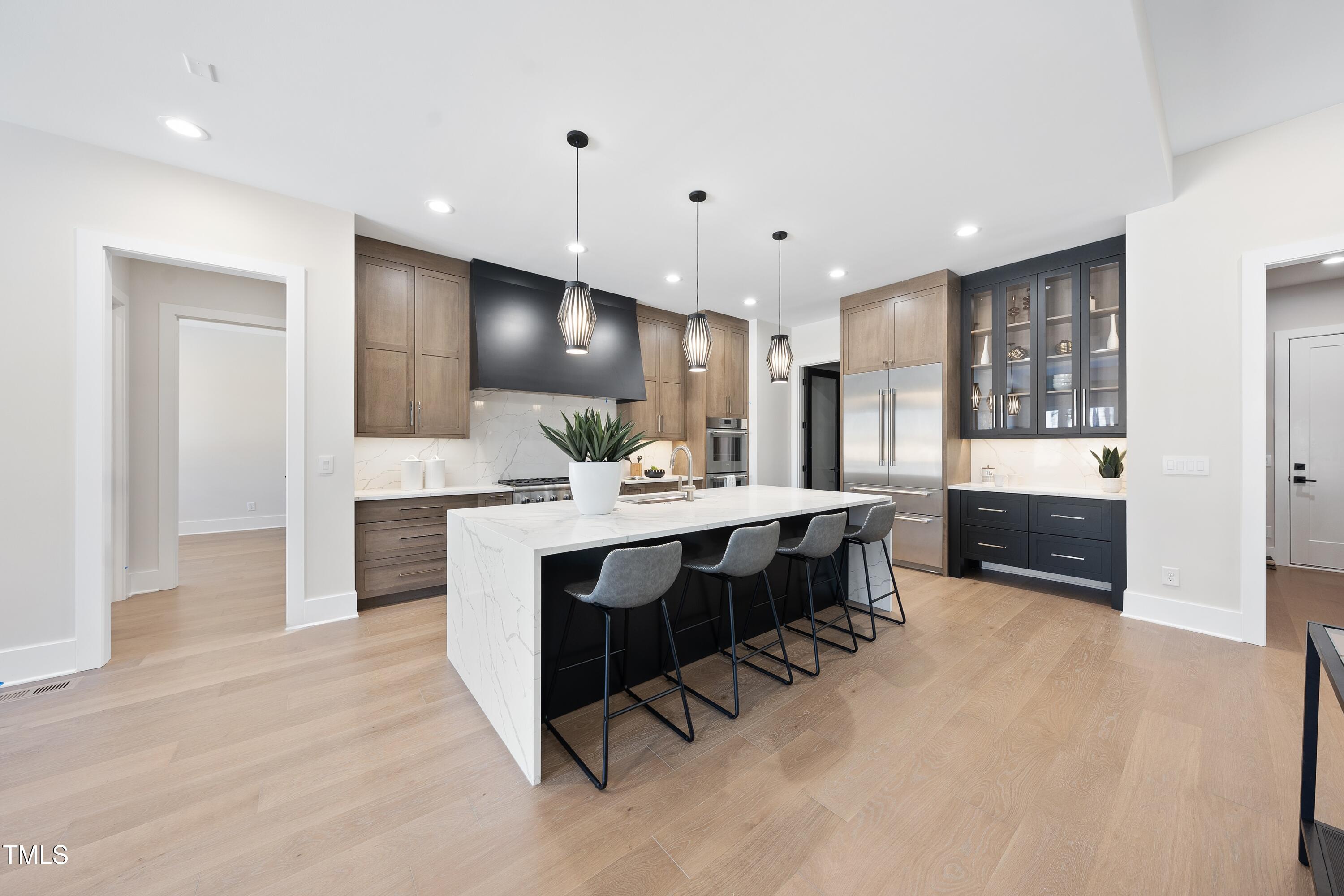 662 Manchester Drive Raleigh, NC 27609 - Photo 7 of 46 a large white kitchen with a large island in the center