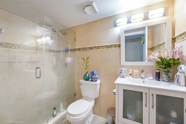 a bathroom with a sink vanity mirror and toilet