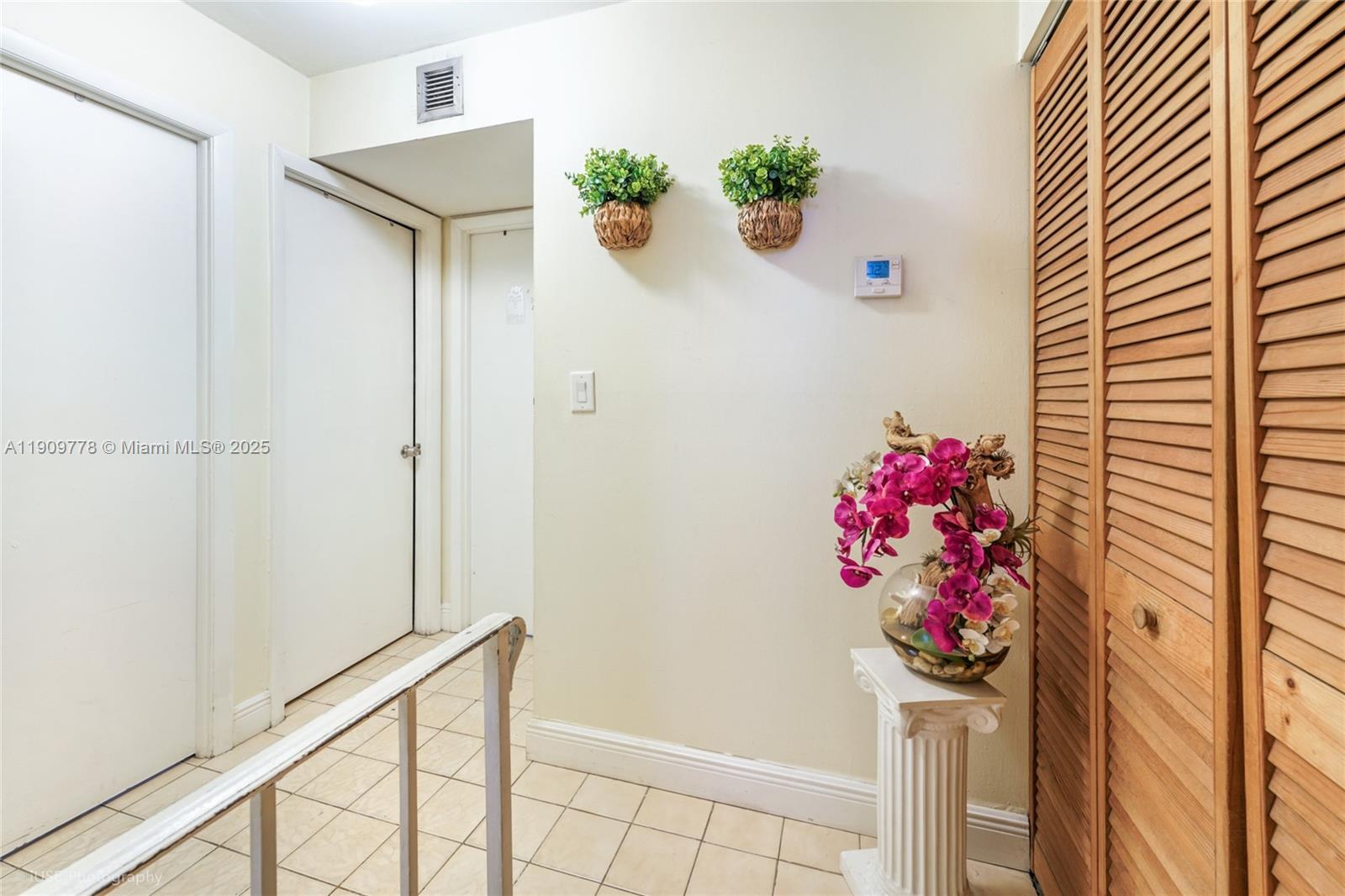 3900 West 11 Avenue, Unit 55 Hialeah, FL 33012 - Photo 9 of 12 a pink flowers in front of a white door