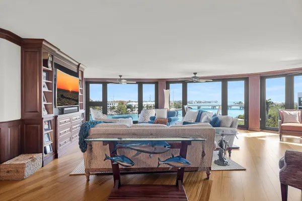 a living room with large windows and a chandelier