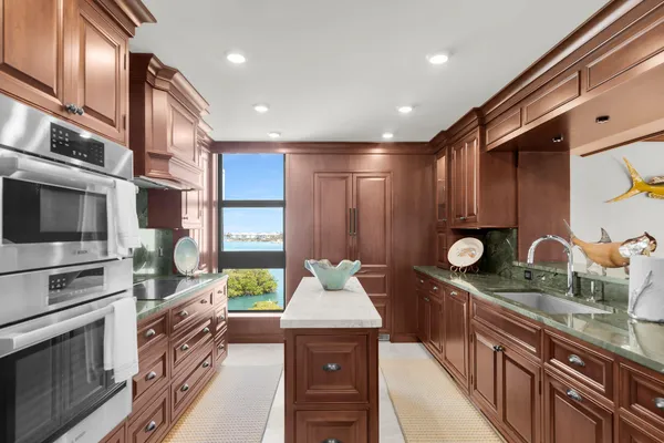 a kitchen with stainless steel appliances granite countertop a stove a sink and a microwave