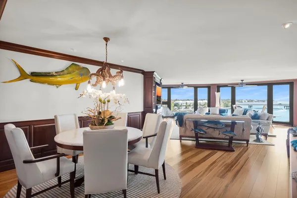 a dining room with furniture a chandelier and wooden floor