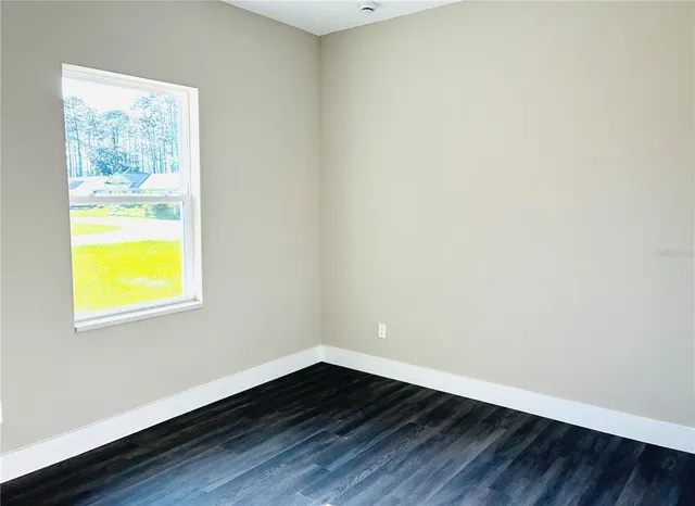 an empty room with wooden floor and a bathroom
