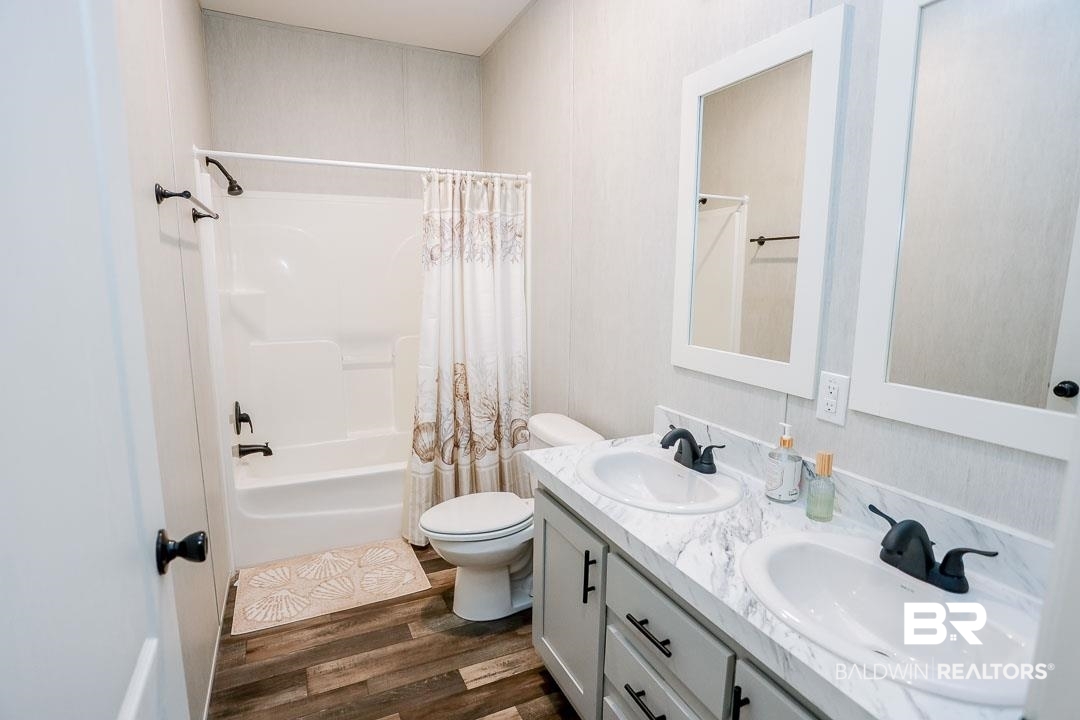 19180 Horseshoe Circle Seminole, AL 36574 - Photo 19 of 38 Full bathroom featuring shower / bathtub combination with curtain, dark wood-style floors, and double vanity