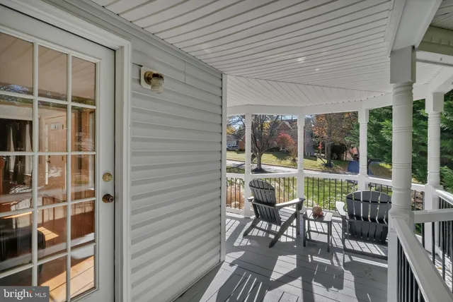 a view of a balcony with chairs and wooden floor