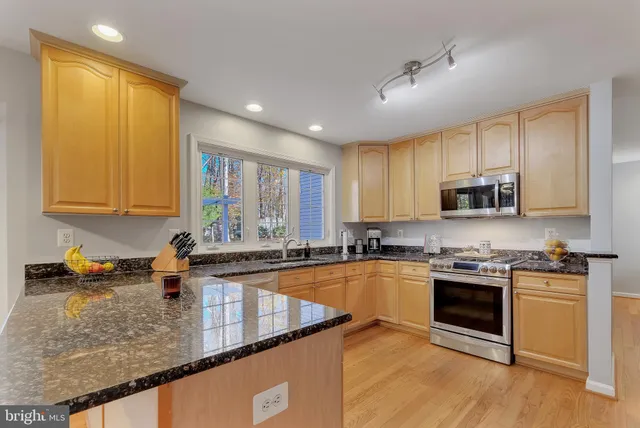 a kitchen with stainless steel appliances granite countertop a stove a microwave and cabinets