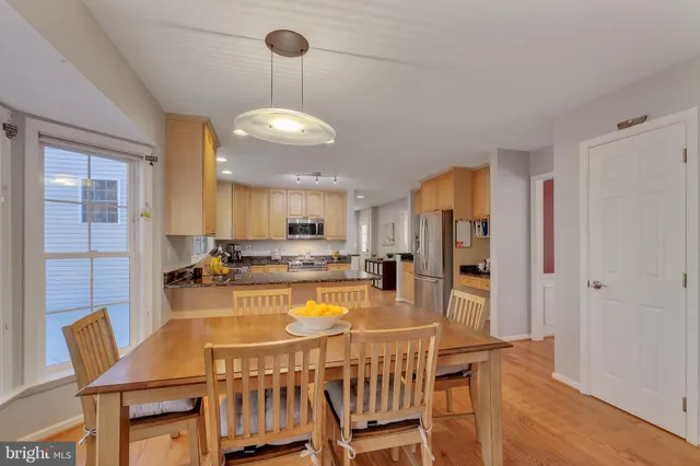 a kitchen with a dining table chairs stove refrigerator and living room