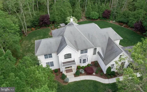 a aerial view of a house with a yard and trees
