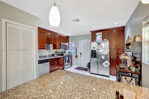 a kitchen with stainless steel appliances kitchen island granite countertop a stove and cabinets