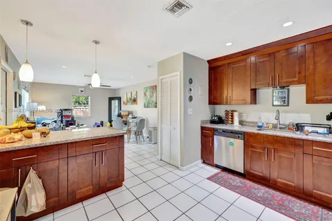 a kitchen with stainless steel appliances a sink cabinets and wooden floor