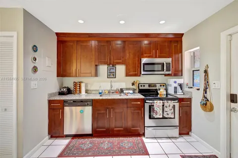 a kitchen with stainless steel appliances granite countertop a stove top oven a sink and dishwasher