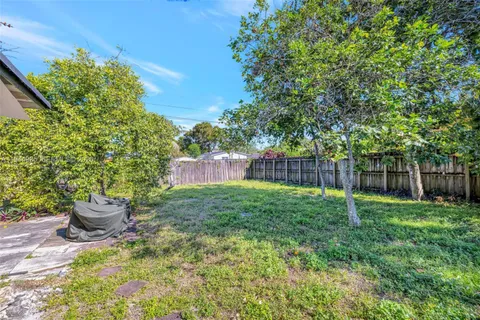 a view of a backyard with table and chairs and potted plants