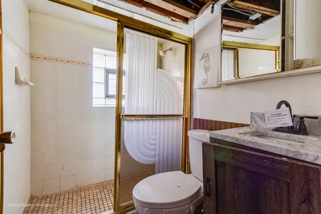 a bathroom with a sink a toilet and shower