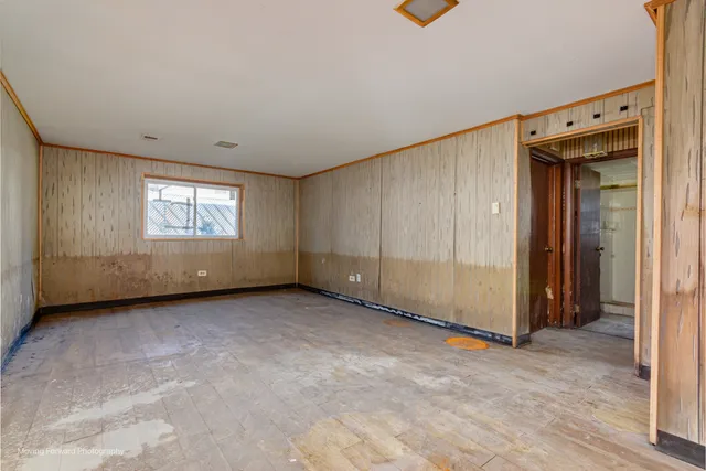 a view of an empty room with window and closet area
