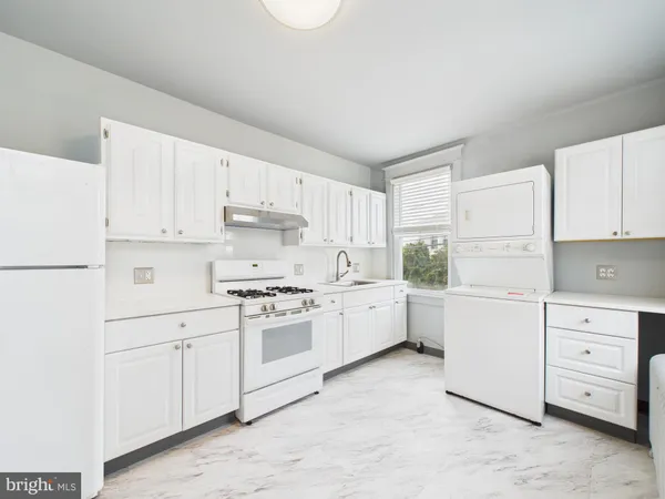a kitchen with white cabinets and white appliances
