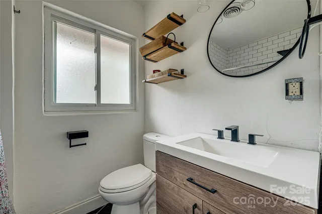 a bathroom with a toilet sink and mirror