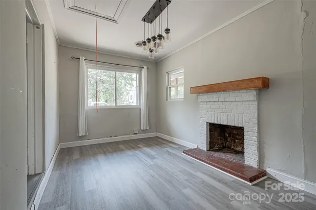 a view of an empty room with wooden floor and closet