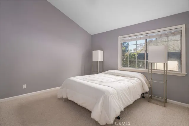 a large bed sitting in a bedroom next to a window
