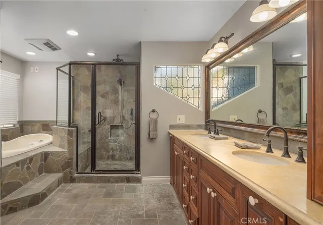 a bathroom with a double vanity sink mirror and shower