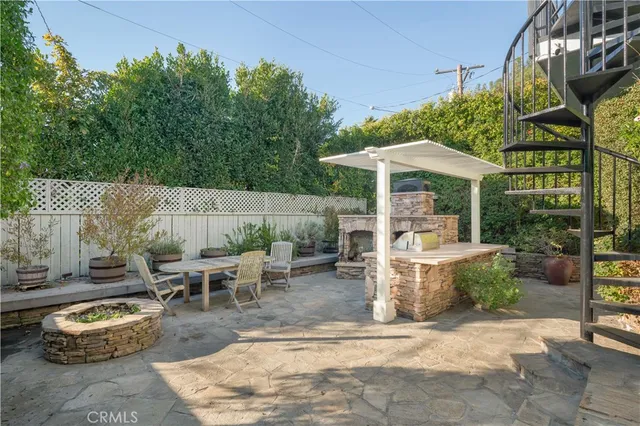 a view of a patio with table and chairs potted plants and floor to ceiling window
