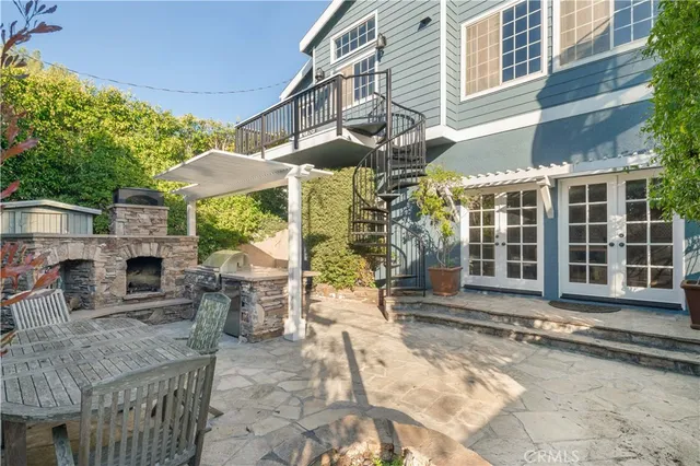 a view of a chairs and table in the patio with a barbeque grill