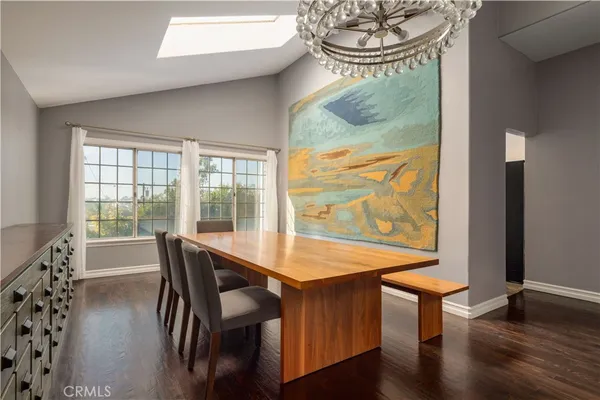a dining room with furniture a chandelier and wooden floor