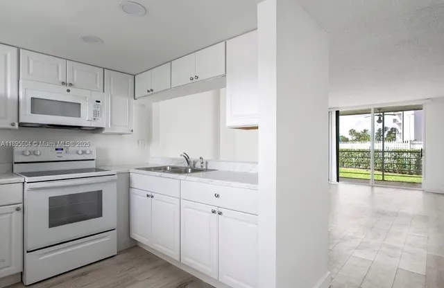 a kitchen with stainless steel appliances white cabinets and a stove top oven