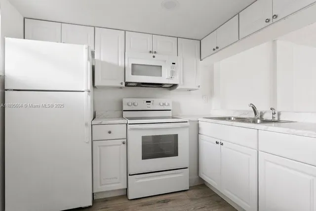 a kitchen with cabinets appliances a sink and a counter top