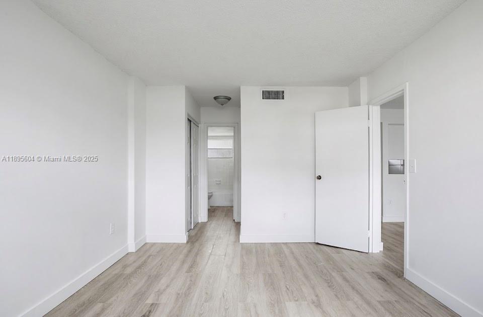 14140 Southwest 84th Street, Unit 104H Miami, FL 33183 - Photo 7 of 13 a view of an empty room and wooden floor
