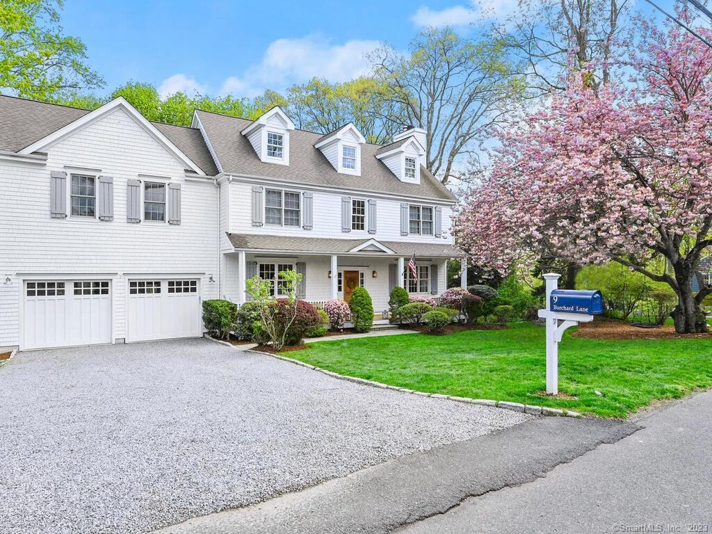 a front view of a house with a garden and trees