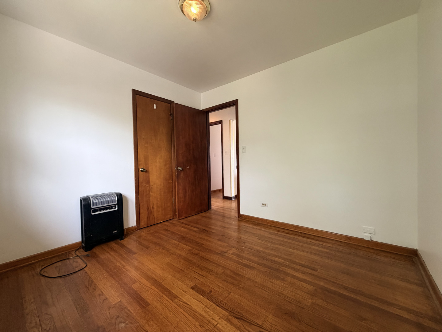 128 North York Road Bensenville, IL 60106 - Photo 14 of 39 a view of an empty room with wooden floor and a window