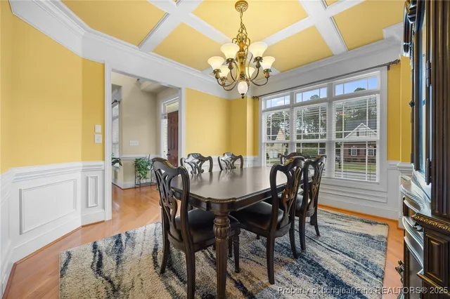 a view of a dining room with furniture a chandelier and wooden floor