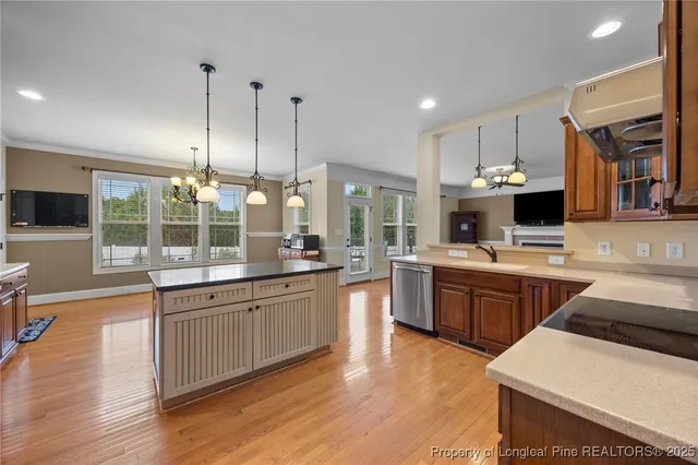 a kitchen with stainless steel appliances kitchen island granite countertop a sink stove and wooden floor