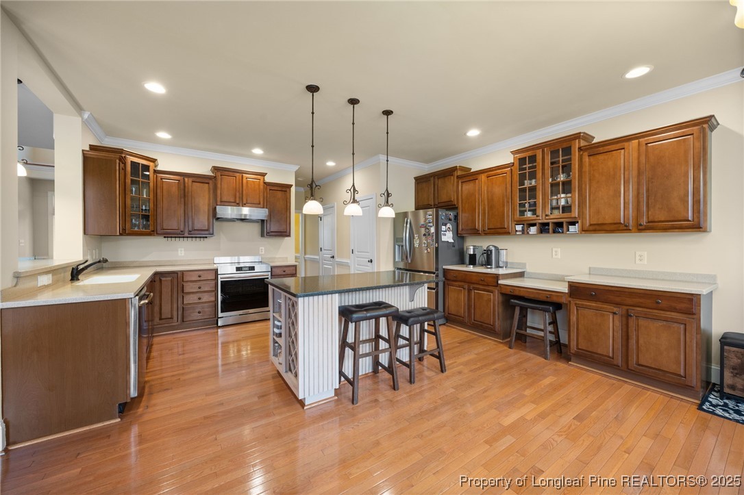 335 Lancelot Court Linden, NC 28356 - Photo 35 of 50 a kitchen with kitchen island granite countertop wooden cabinets and a refrigerator