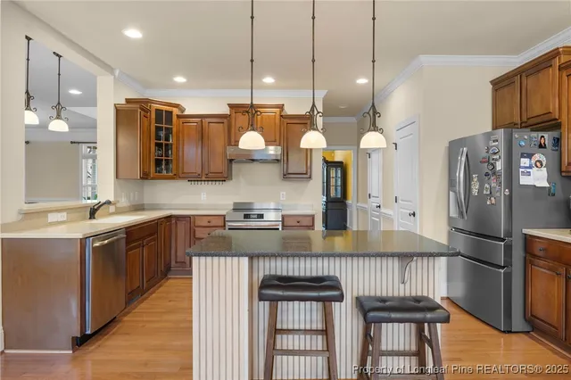 a kitchen with stainless steel appliances granite countertop a stove a sink and a refrigerator