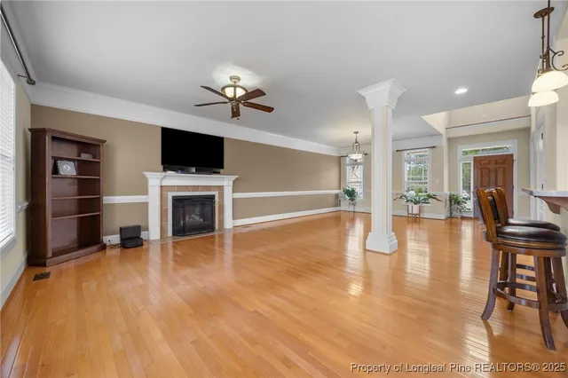 a view of a livingroom with furniture a flat screen tv and kitchen view