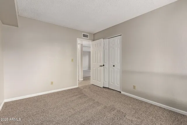 a bedroom with a bed and a painting on the wall