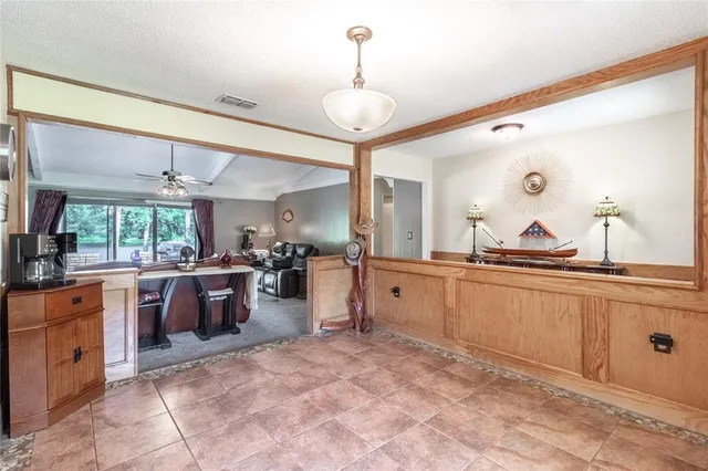 a large kitchen with kitchen island a counter a sink cabinets and stainless steel appliances