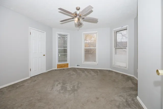 an empty room with closet and windows