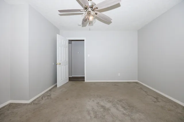 an empty room with a fan and a fan