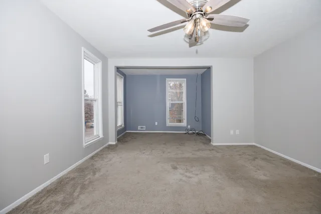 an empty room with chandelier fan