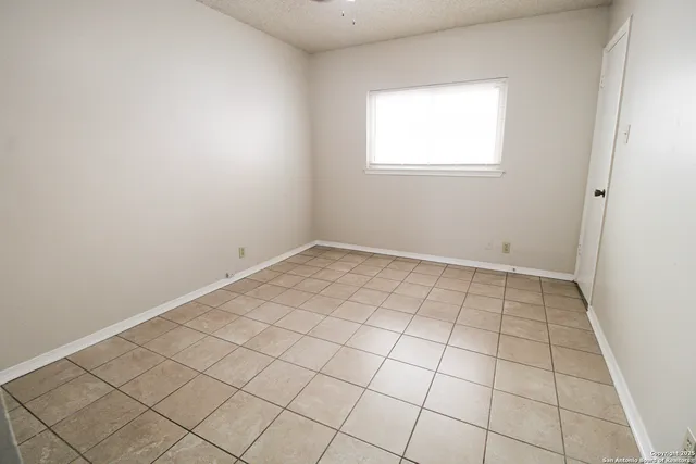 an empty room with white walls washer and dryer
