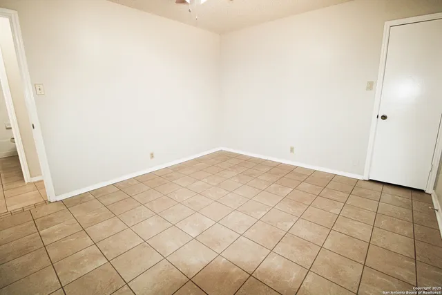 an empty room with windows and fan