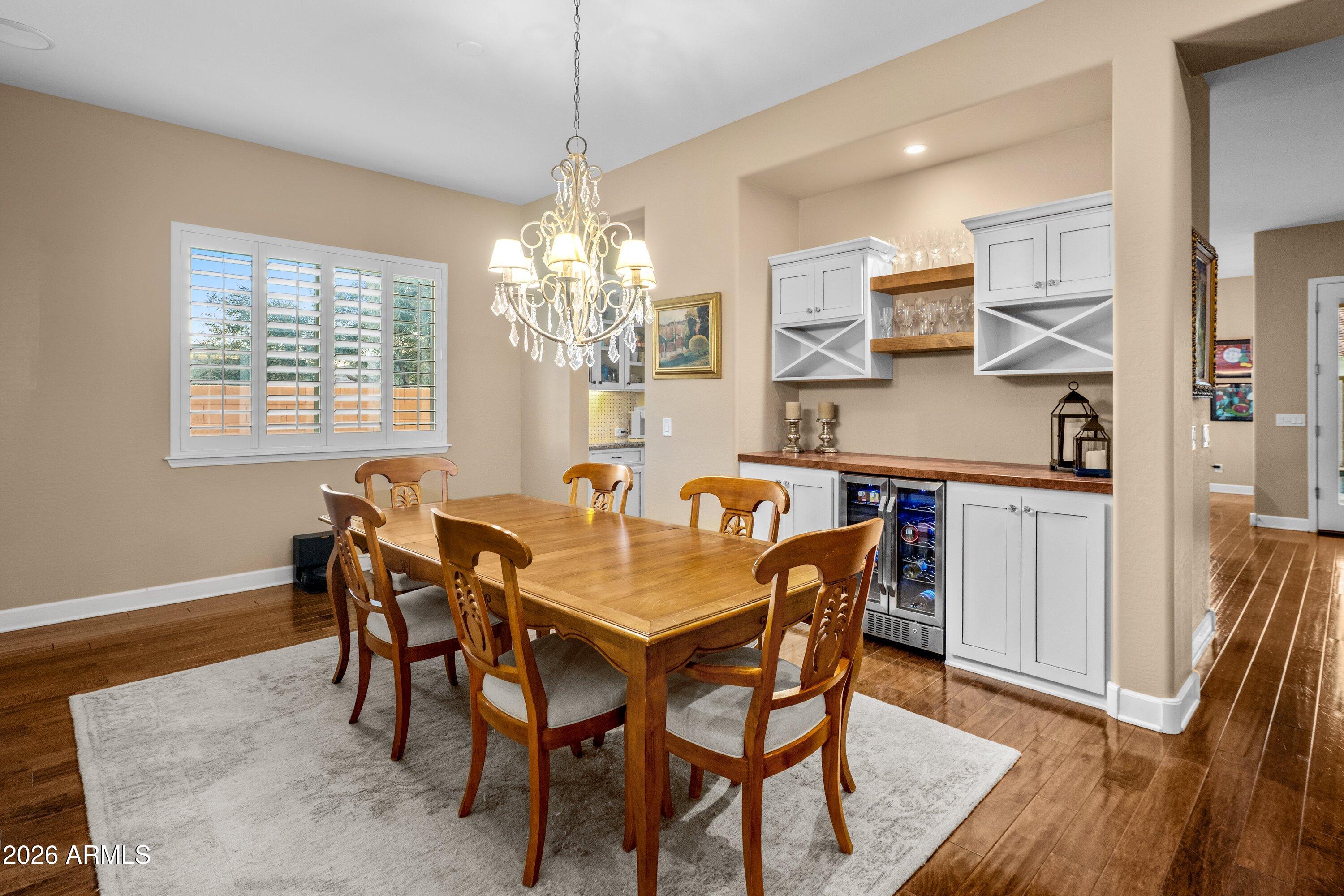 3738 East Riopelle Avenue Gilbert, AZ 85298 - Photo 10 of 97 a dining room with furniture a chandelier and wooden floor
