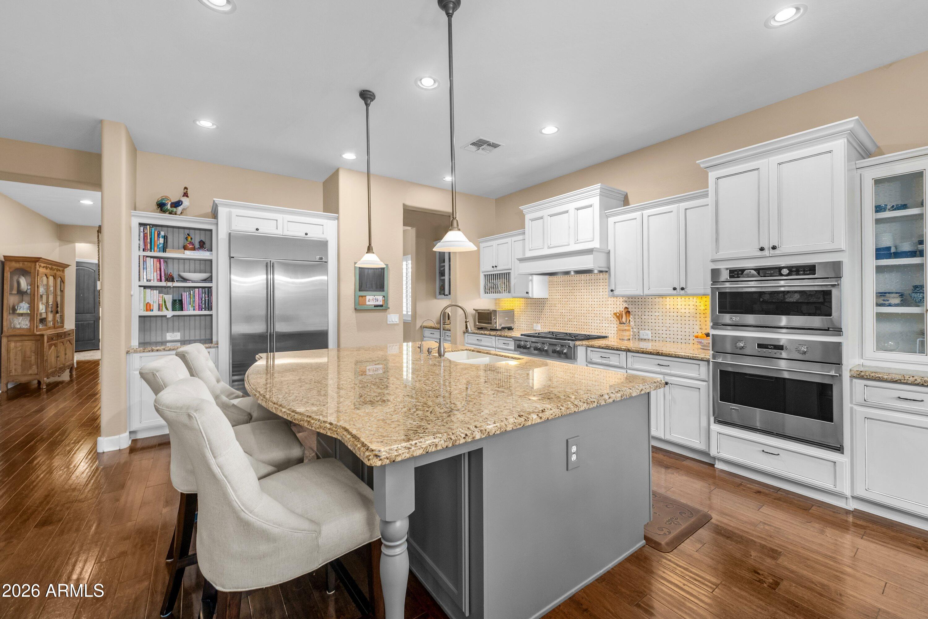 3738 East Riopelle Avenue Gilbert, AZ 85298 - Photo 19 of 97 a kitchen with stainless steel appliances granite countertop a kitchen island a stove a table and chairs